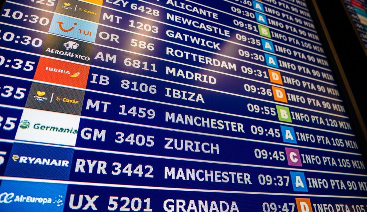 PALMA DE MALLORCA, SPAIN - MAY 8, 2018: View from below of large details of a typical airport information board with mutiple airlines and cities hours departure gates and insignia for the boarding gate